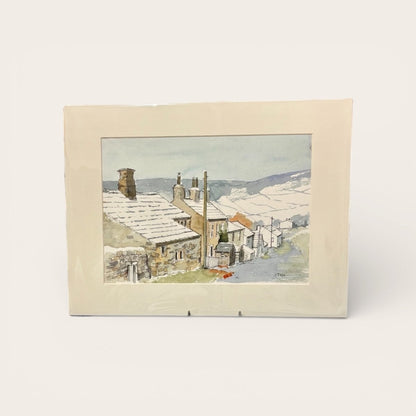 Framed artwork of a snowy village scene with houses and chimneys.