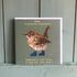 Card with a wren illustration and text on a wooden surface