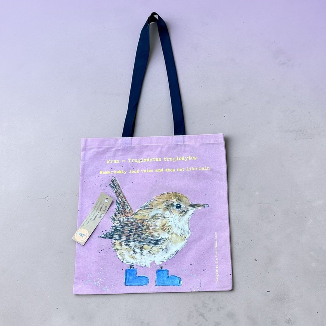 Tote bag with a bird design on a light purple background