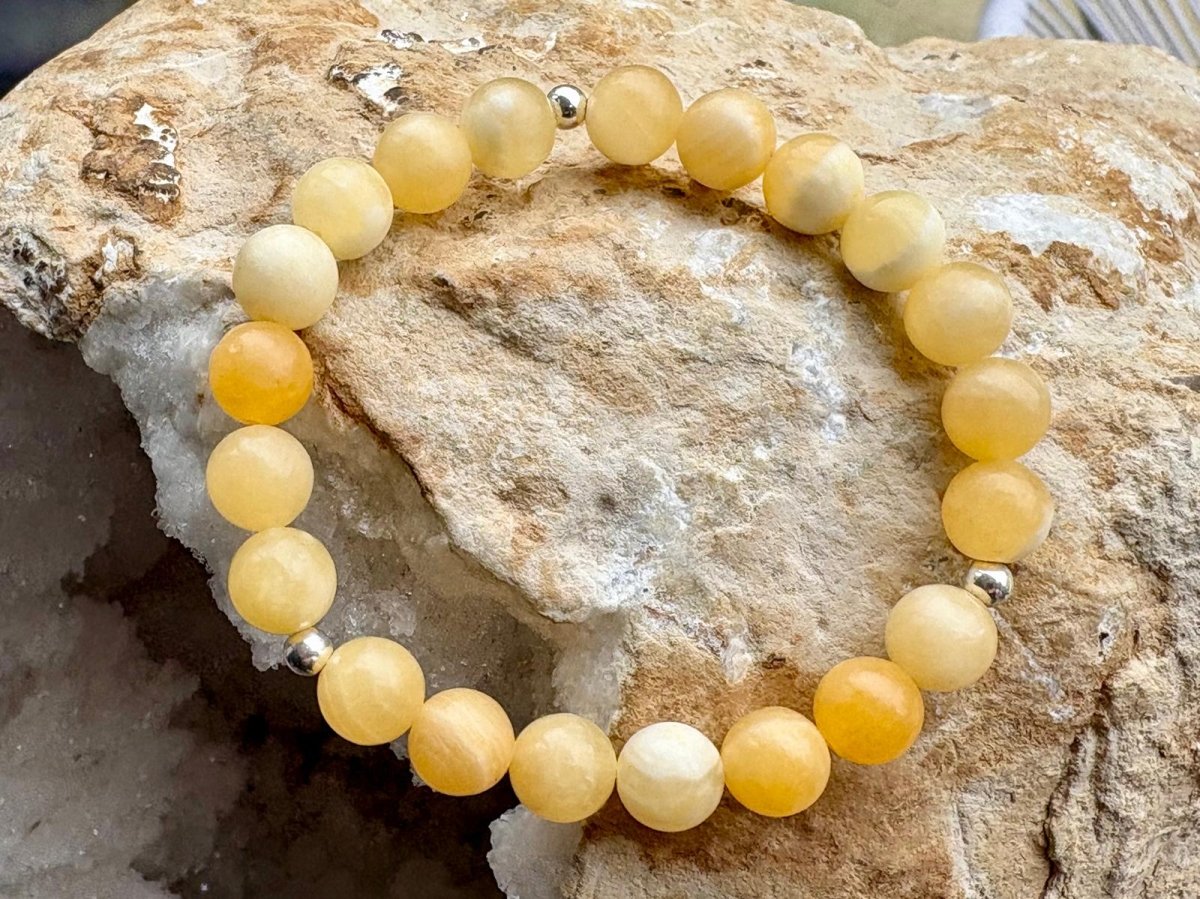 Yellow beaded bracelet on a textured stone surface