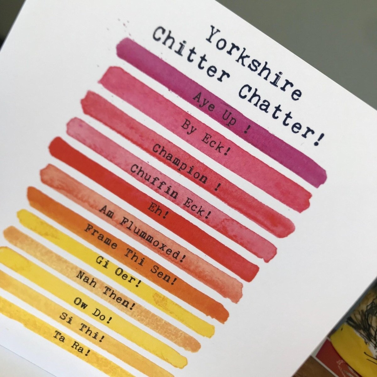 Card with Yorkshire dialect phrases and colorful bars on a white background