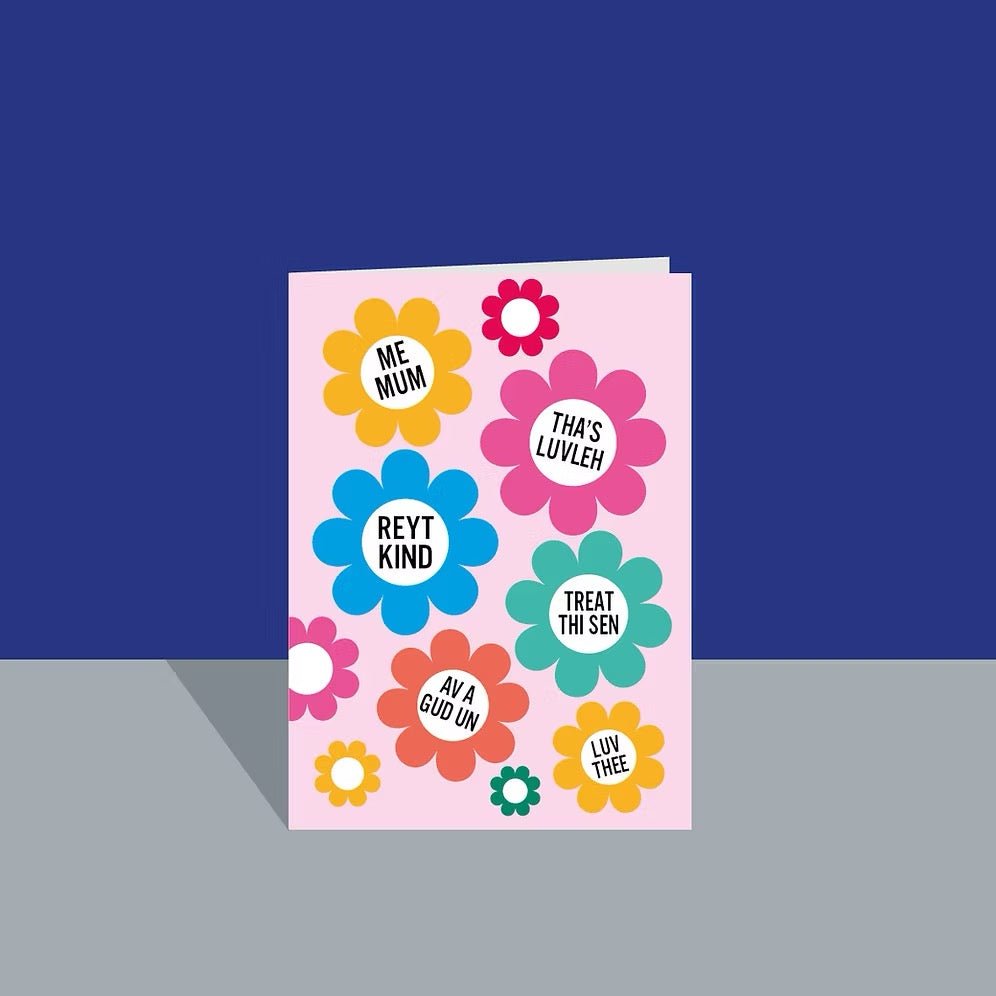 Pink card with colorful flowers and Yorkshire phrases on a blue background