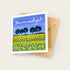 Greeting card with a field of flowers and trees, and &
